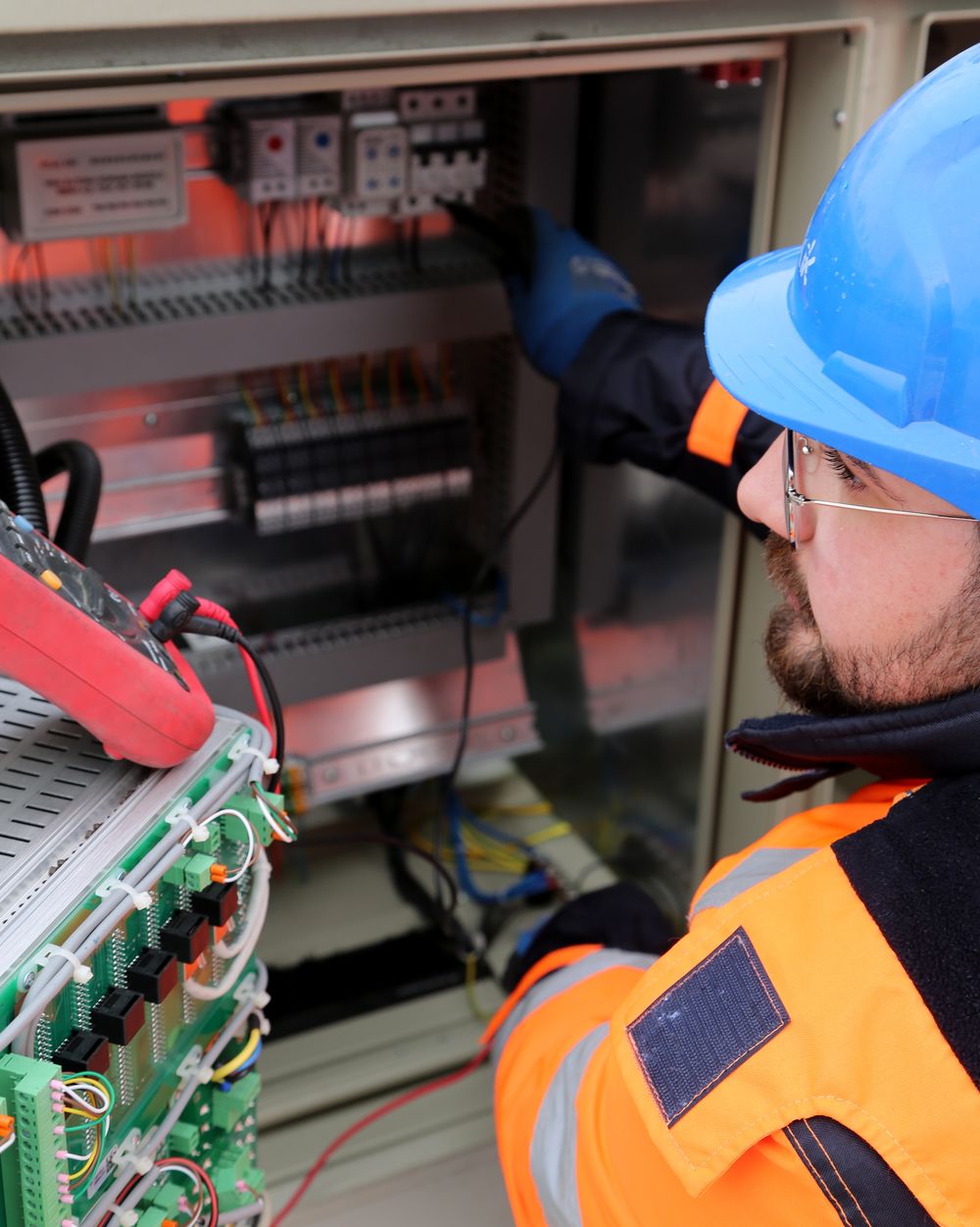 Technician inspecting an industrial electrical panel